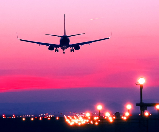 image of airplane landing at sunset
